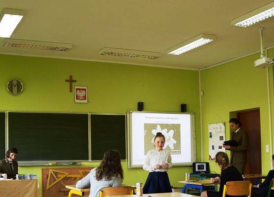 Zadowolana mina uczestniczki po prawidłowym rozpoznaniu gatunku rośliny na prezentacji.